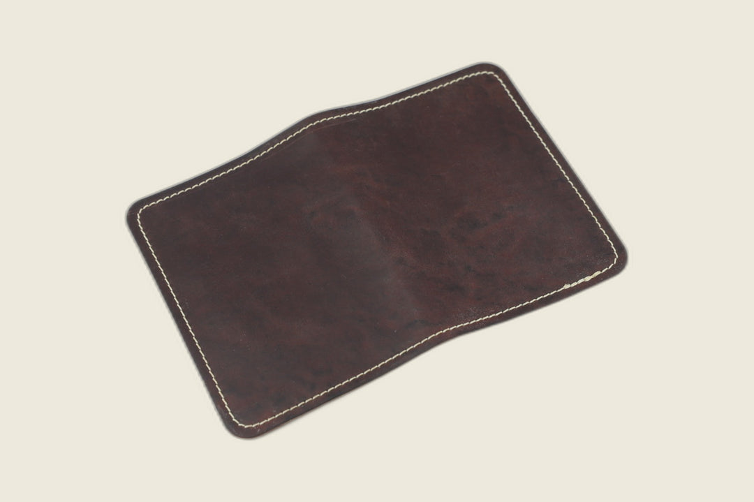 Warden bifold wallet in tumbled Color 8 Horween shell cordovan, deep burgundy exterior, cream backdrop