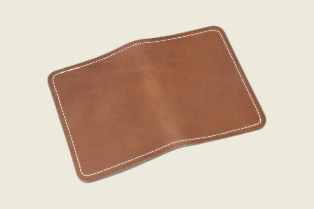 Warden bifold wallet in unglazed natural Horween shell cordovan, warm brown exterior, cream flat lay