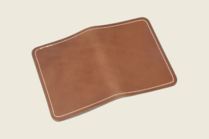 Warden bifold wallet in unglazed natural Horween shell cordovan, warm brown exterior, cream flat lay