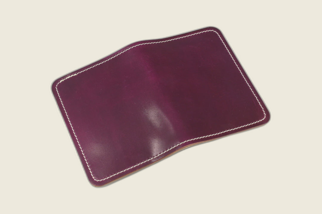 Warden bifold wallet in ultraviolet Horween shell cordovan, deep purple exterior, cream flat lay