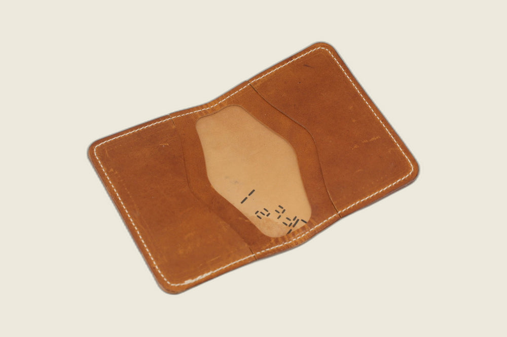 Warden bifold opened to English tan Cypress horsehide card pockets with stamped hide markings