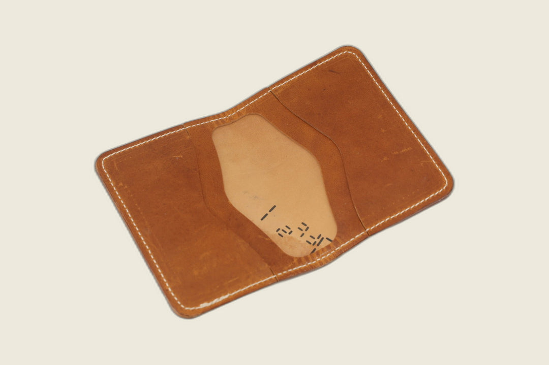 Warden bifold opened to English tan Cypress horsehide card pockets with stamped hide markings