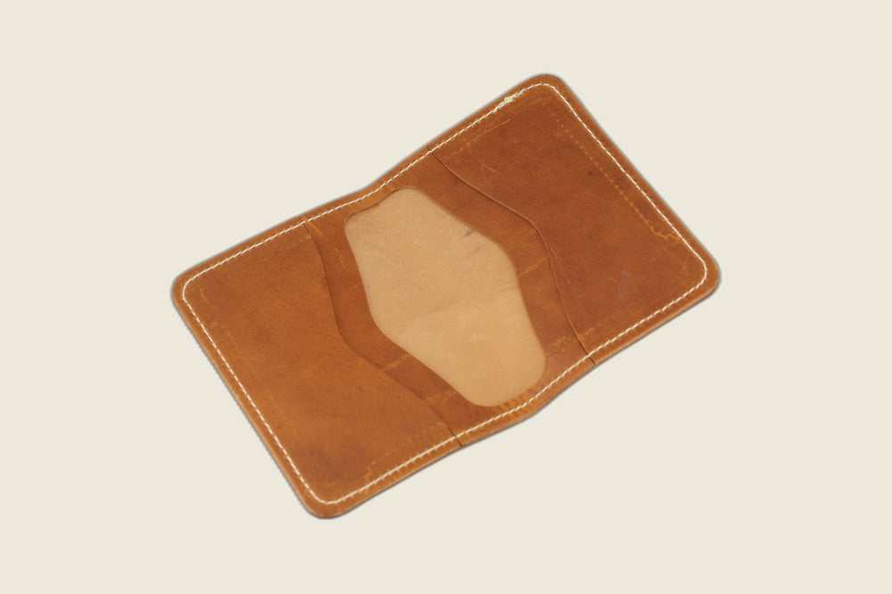 Warden bifold opened to two card pockets in English tan Horween Cypress horsehide, cream flat lay