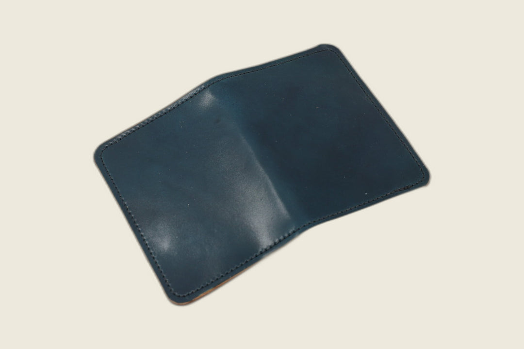 Warden bifold wallet in navy Horween shell cordovan laid open flat, exterior view, cream backdrop