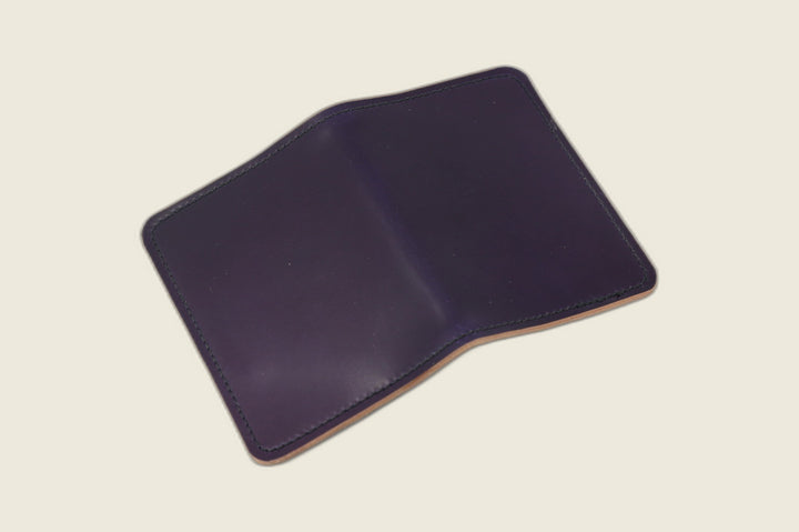 Warden bifold wallet in violet Horween shell cordovan, dark purple exterior, cream flat lay