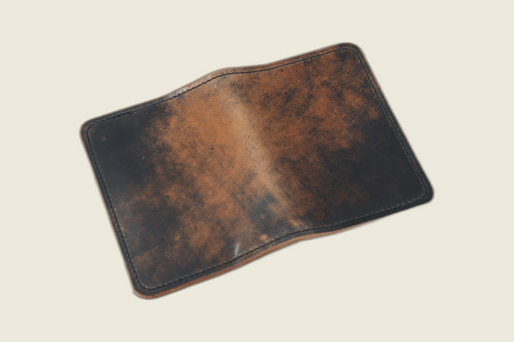 Warden bifold wallet in marbled black Rocado shell cordovan, black-over-tan marbling, cream backdrop