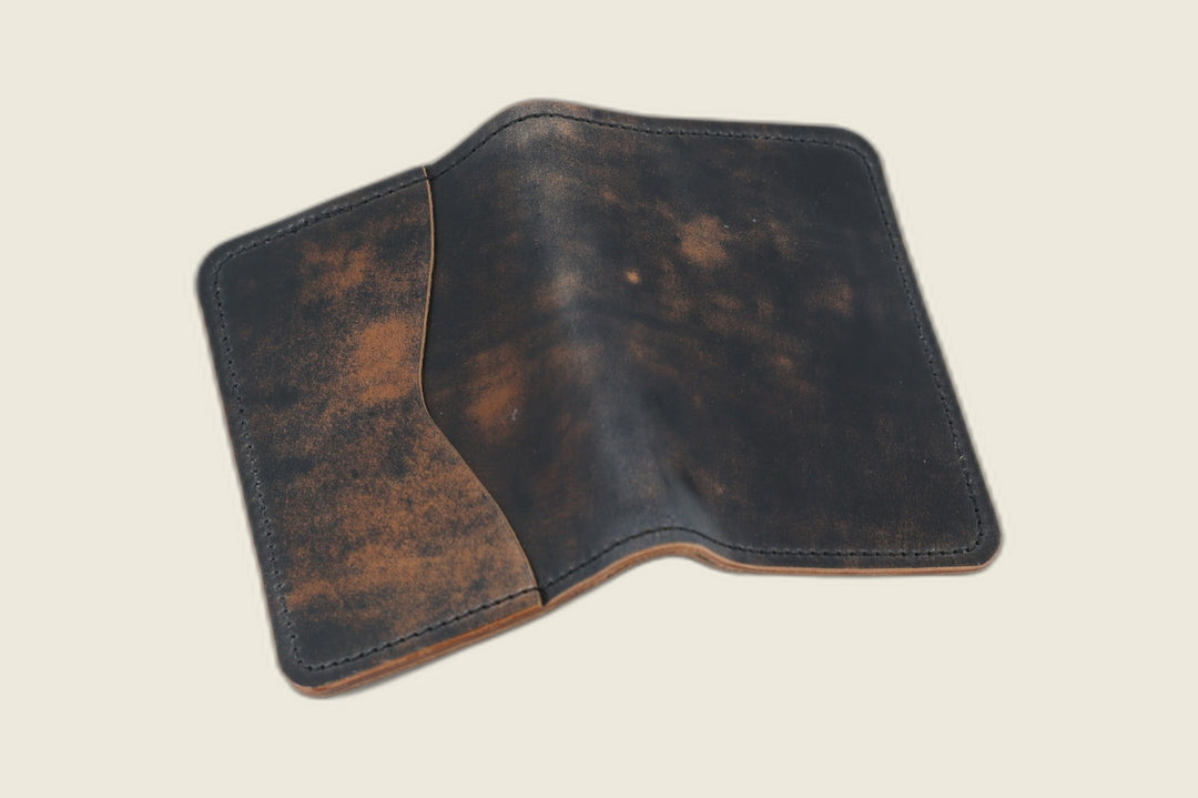 Warden bifold wallet in marbled black Rocado shell cordovan, smoky tan mottling, cream backdrop