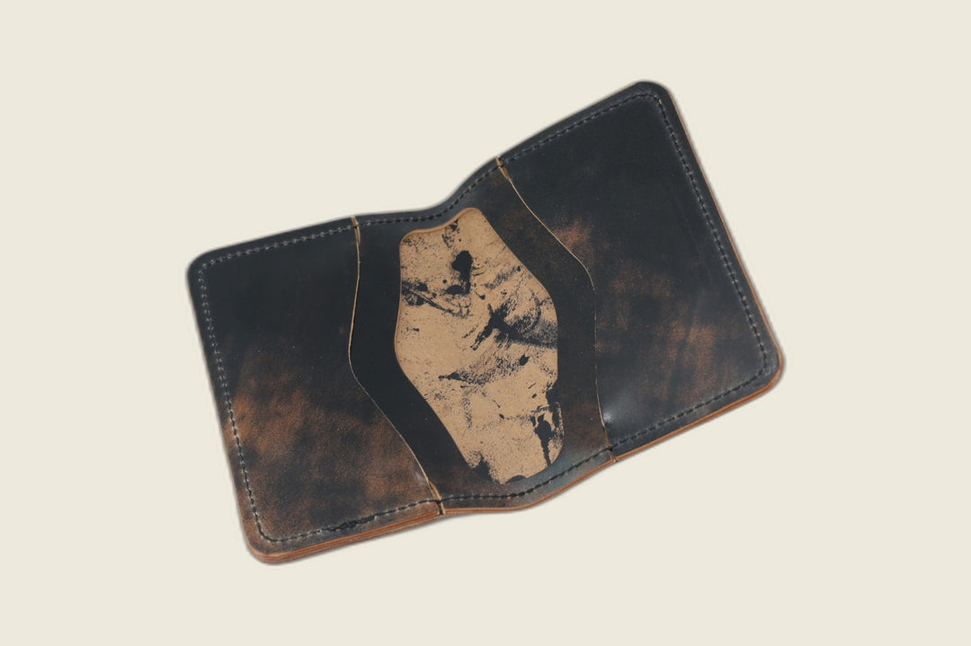 Warden bifold opened to marbled black Rocado pockets with a black-dappled tan well