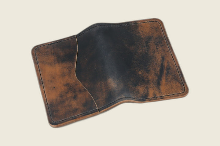 Warden bifold wallet in marbled black Rocado shell cordovan, copper-flecked exterior, cream backdrop
