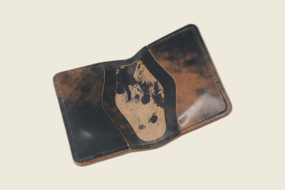 Warden bifold opened to marbled black card pockets, tan well boldly splashed with black