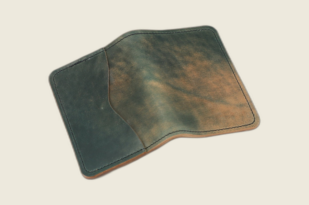 Warden bifold wallet in marbled green Rocado shell cordovan, green and rust marbling, cream flat lay