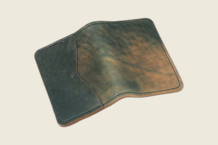 Warden bifold wallet in marbled green Rocado shell cordovan, green and rust marbling, cream flat lay