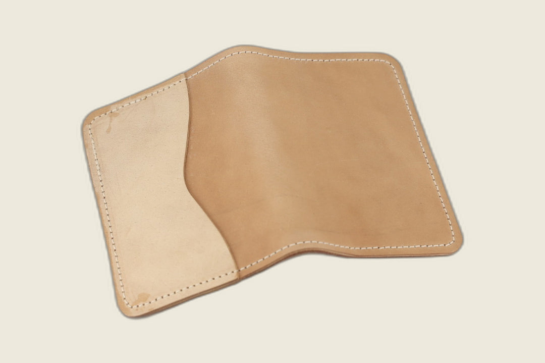 Warden bifold wallet in unglazed natural Cloe shell cordovan, light sand exterior, cream backdrop