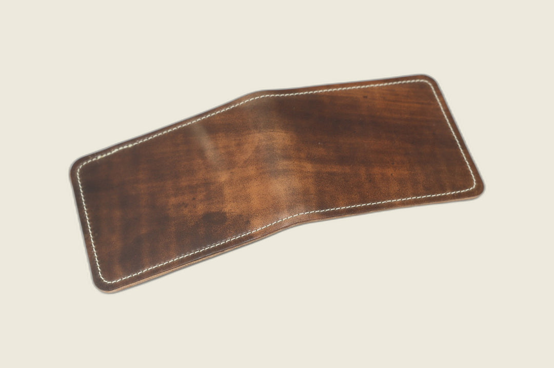 Stronghold bifold wallet in marbled whiskey shell cordovan, open flat showing the mottled exterior grain