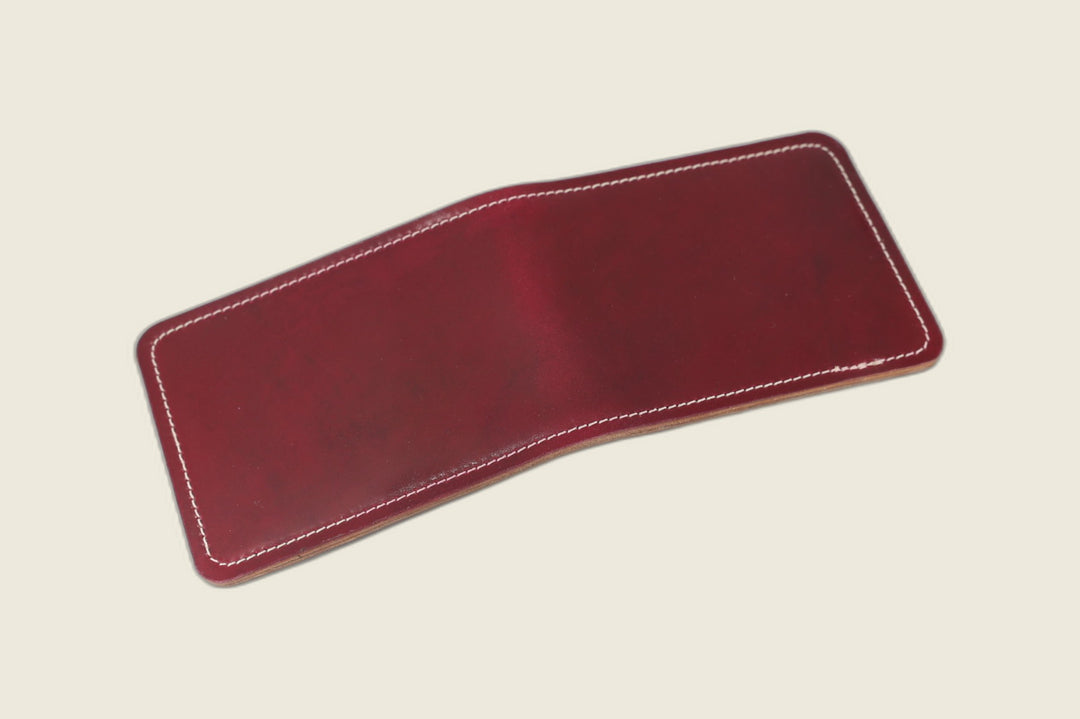 Stronghold bifold wallet in Rocado ultraviolet shell cordovan, deep red-violet sheen, open flat with white stitching