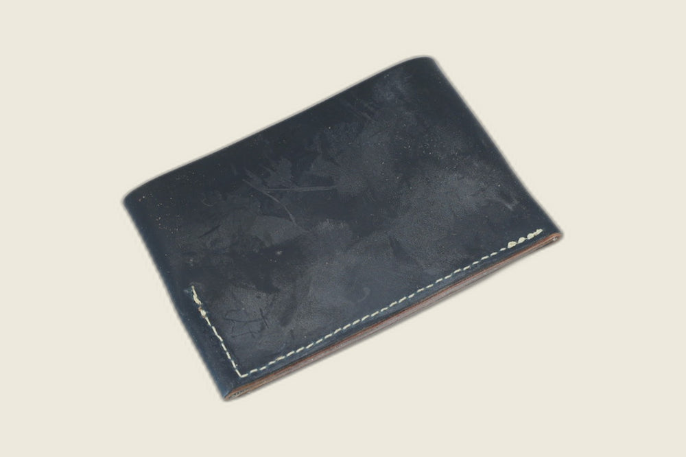Back of the navy shell cordovan Sentinel wallet showing matte marbled surface and corner stitching