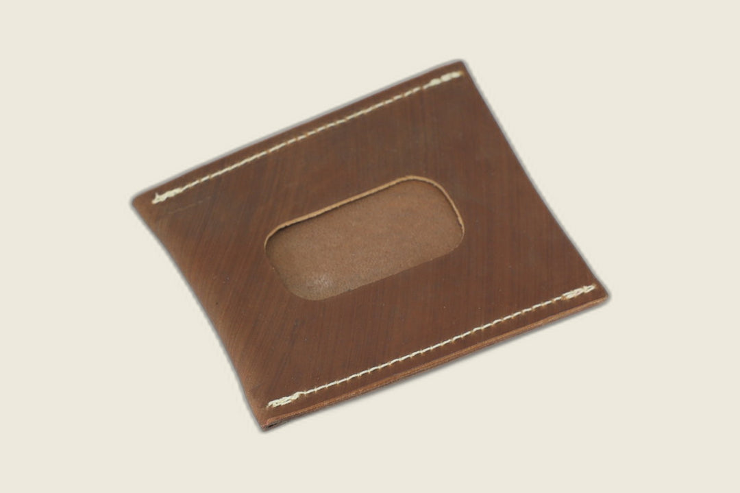 ID window side of the light brown Toscana shell cordovan sleeve, cutout revealing tan suede, angled on cream