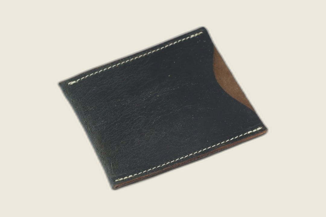 Safeguard sleeve front in navy Horween workshoe butt, deep pull-up sheen, cream stitching and thumb scoop