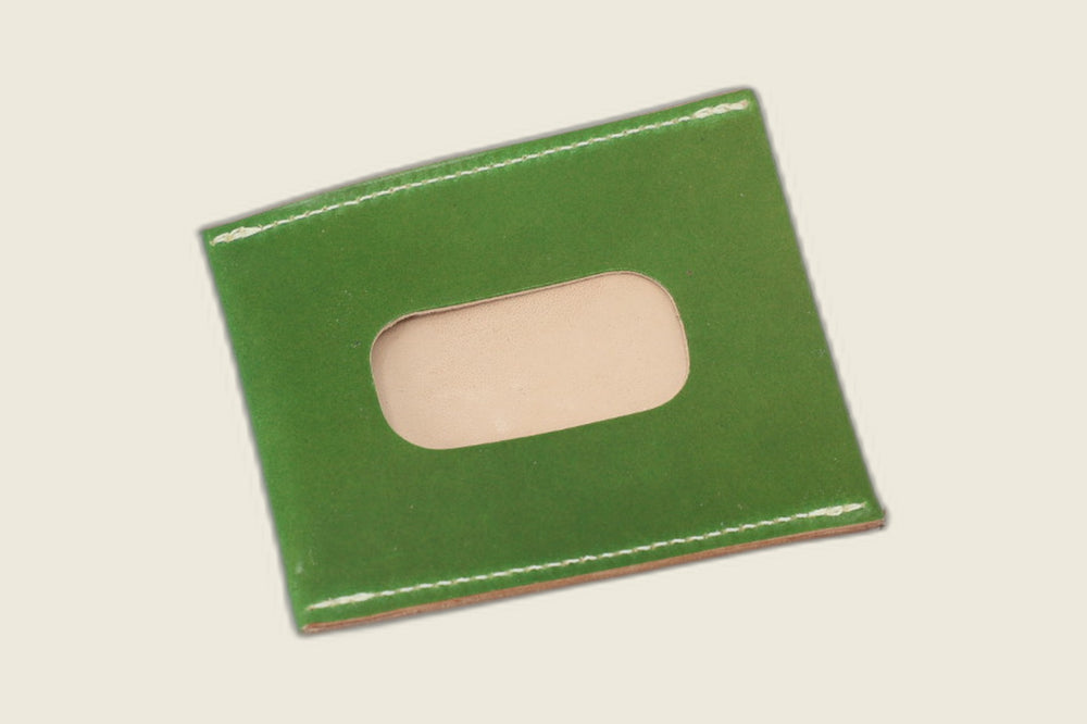 ID window side of the candy apple green shell cordovan sleeve, cutout revealing pale natural leather