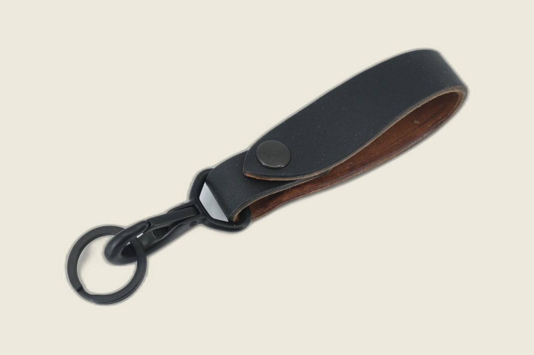 Lanyard in black Horween workshoe butt with black snap and swivel clasp on a matte key ring, tan flesh side showing