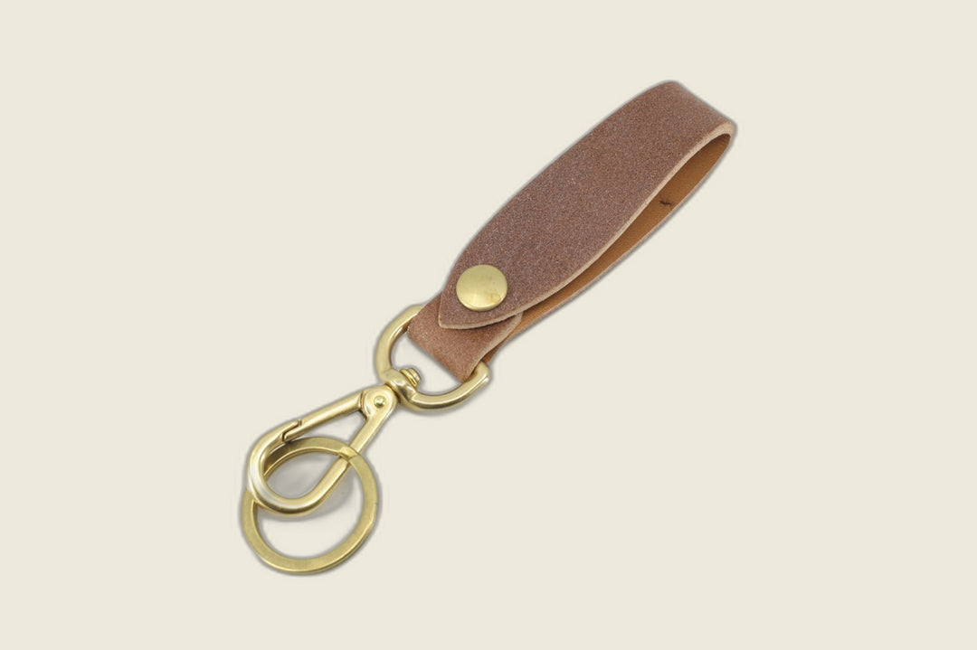 Lanyard in J&FJ natural waxed flesh harness, matte napped finish, brass snap, swivel hook and key ring on cream backdrop