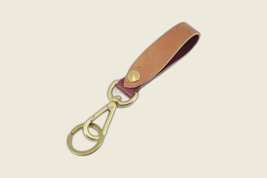 Violet marbled shell cordovan lanyard loop fading tan to plum, brass snap stud, swivel hook and key ring, on cream