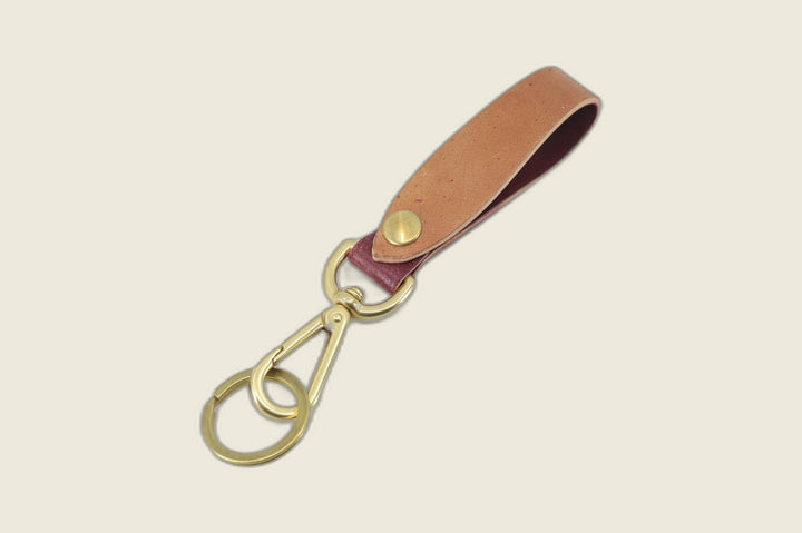 Violet marbled shell cordovan lanyard loop fading tan to plum, brass snap stud, swivel hook and key ring, on cream