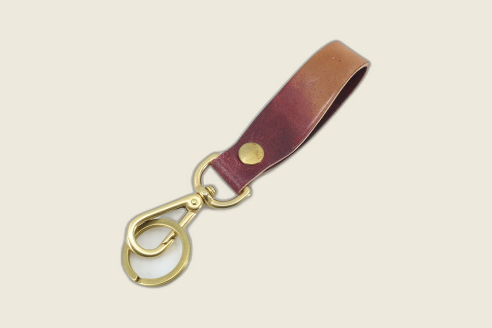 Reverse of the Rocado marbled shell cordovan lanyard showing deeper violet-burgundy tones, brass swivel clasp and key ring