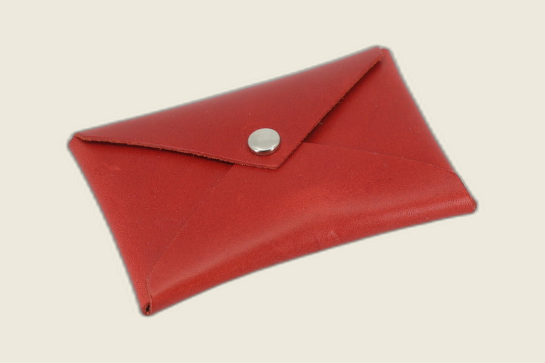 Aegis envelope card wallet in Walpier red Buttero steerhide, smooth grain with nickel snap, angled studio flat lay
