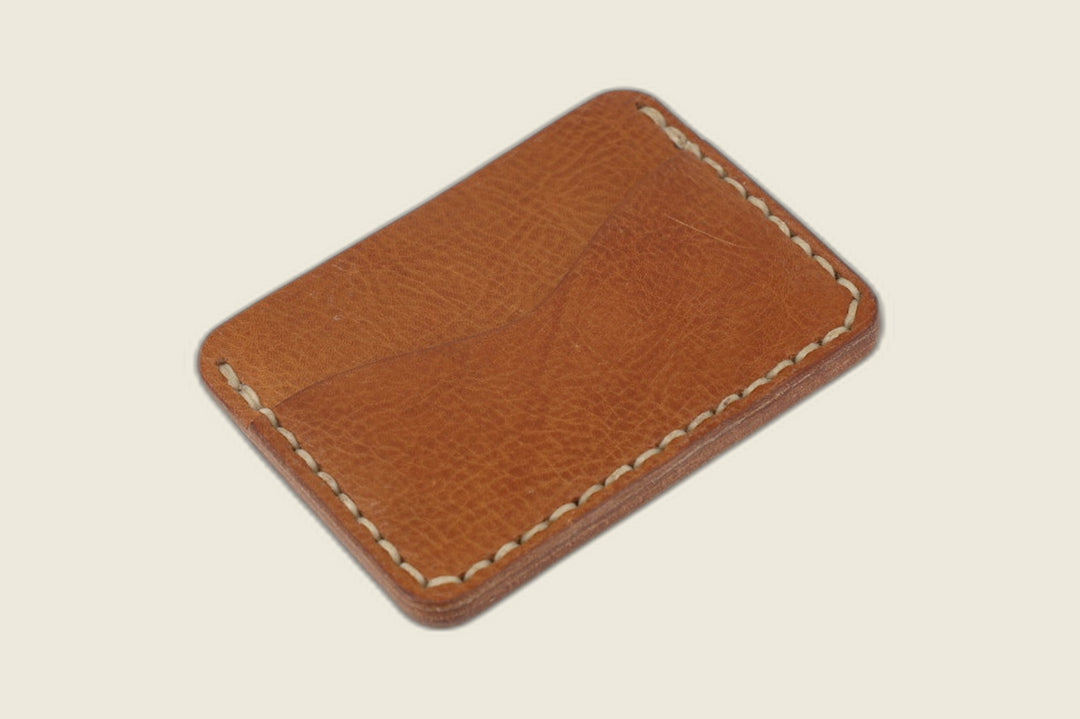 Buckler four-slot card holder in Haas tan calfskin, pebbled grain with cream saddle stitching, slot side up