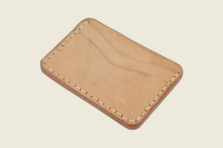 Buckler four-slot card holder in undyed Maryam natural horsebutt with twin curved slots and tonal stitching