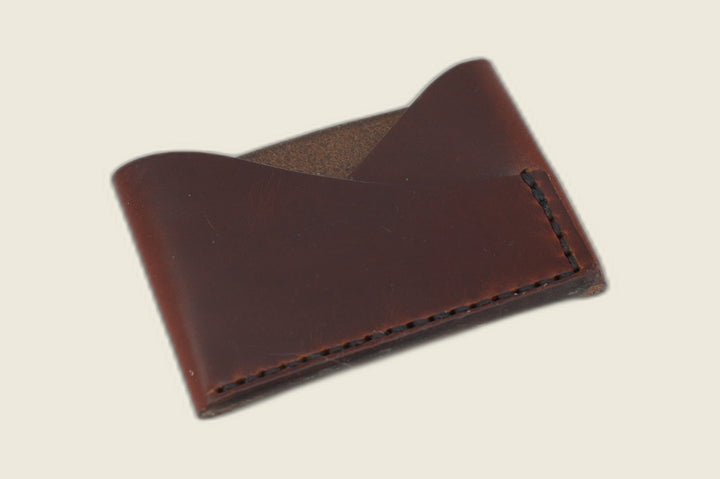 Sentinel card sleeve in Horween tan workshoe horsebutt with burnished red-brown patina, crossed peak pockets