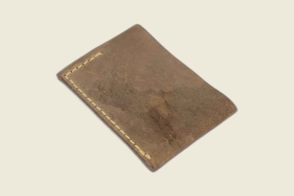 Back panel of the Sentinel fango horsebutt sleeve, distressed matte grain with a yellow stitch line at the edge