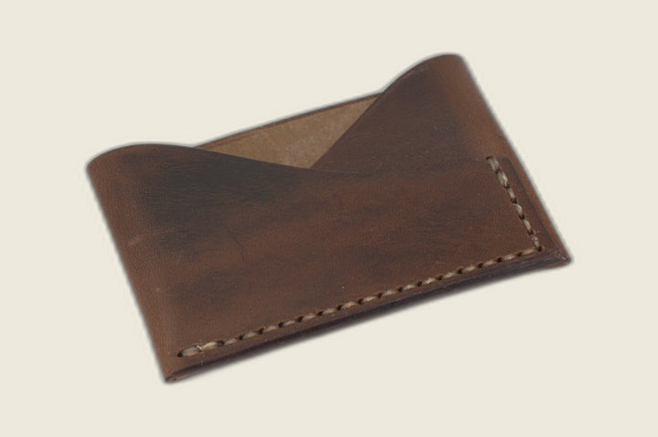 Sentinel card sleeve in Horween natural horsebutt with pull-up sheen, crossed peak front pockets, tan stitching
