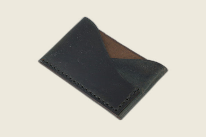 Sentinel card sleeve in deep Horween navy workshoe horsebutt, crossed peak pockets over a brown suede interior