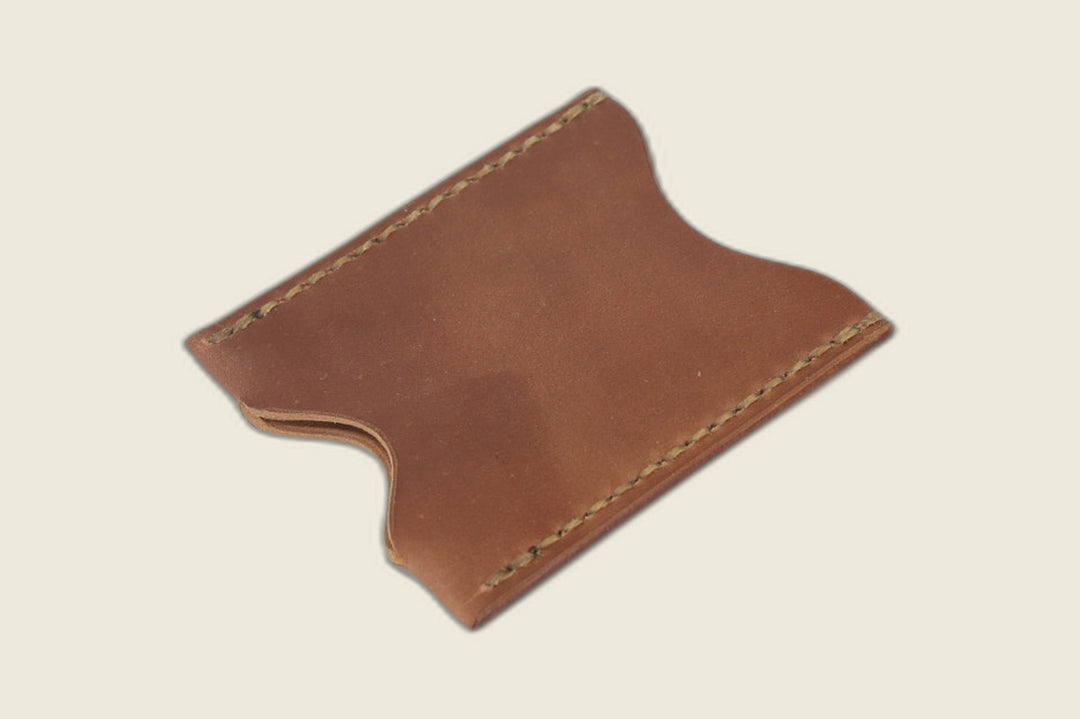 Sentinel card sleeve in Horween unglazed natural shell cordovan with curved thumb notches and olive stitching