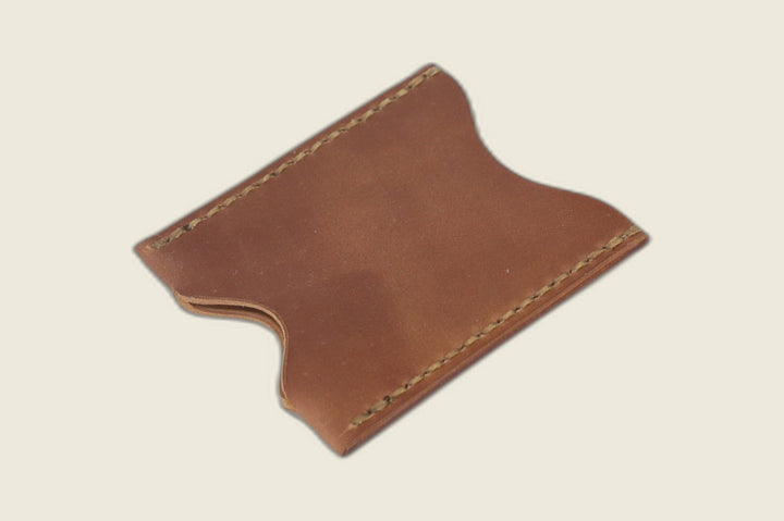 Sentinel card sleeve in Horween unglazed natural shell cordovan with curved thumb notches and olive stitching